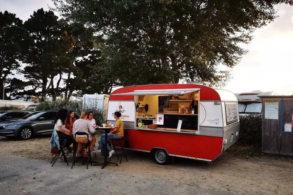 Le food truck La P'tite Bretonne sur un marché du golfe du Morbihan, clients au comptoir